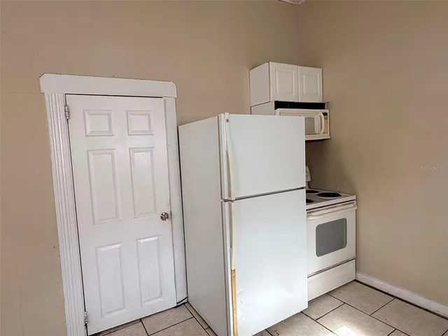 a white refrigerator freezer and a stove sitting inside of a kitchen