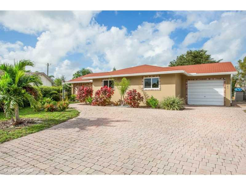 10139 Windtree Lane Boca Raton, FL 33428 - Photo 1 of 15 a view of a white house with a yard and table and chairs under an umbrella