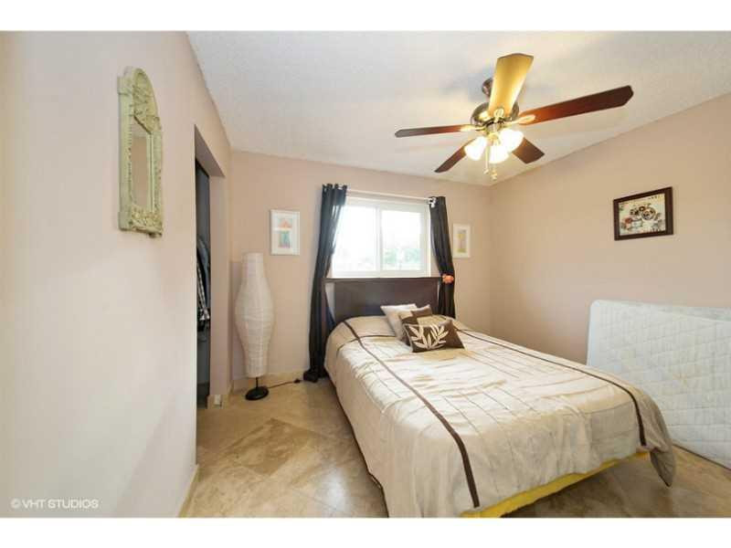 10139 Windtree Lane Boca Raton, FL 33428 - Photo 2 of 15 a bedroom with a bed and a chandelier