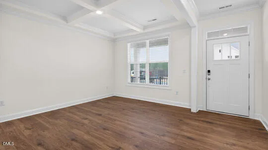a view of empty room with wooden floor