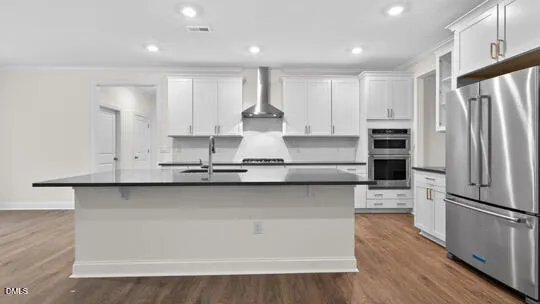 a kitchen with stainless steel appliances granite countertop a refrigerator and a sink