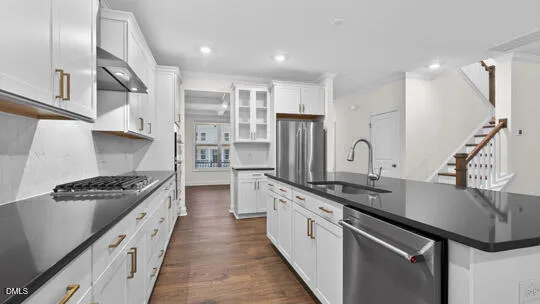a large kitchen with cabinets wooden floor and a sink