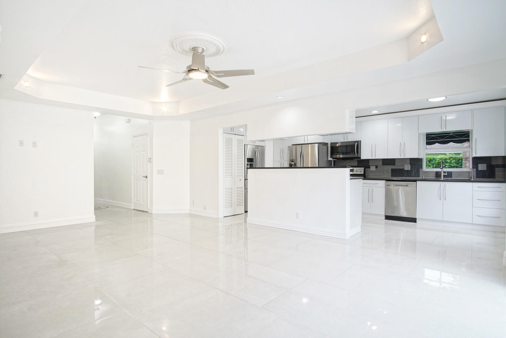 4483 Southeast Murray Cove Circle Stuart, FL 34997 - Photo 7 of 21 a view of a kitchen with a sink and dishwasher a refrigerator with wooden floor