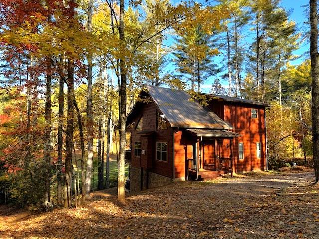 a front view of a house with a tree