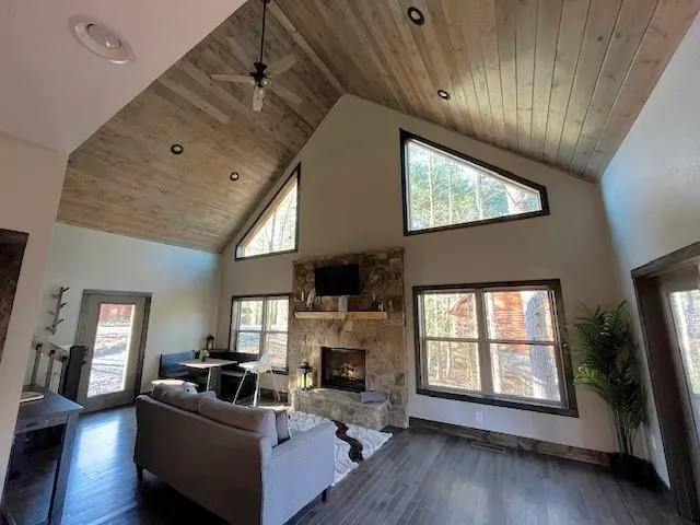 a living room with furniture large window and wooden floor