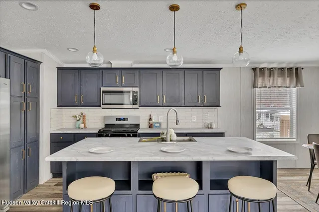 a kitchen with a stove a sink a microwave and wooden cabinets