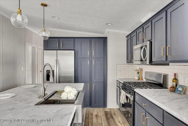 a kitchen with kitchen island granite countertop a sink stove and refrigerator