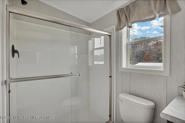 a bathroom with a toilet and a shower