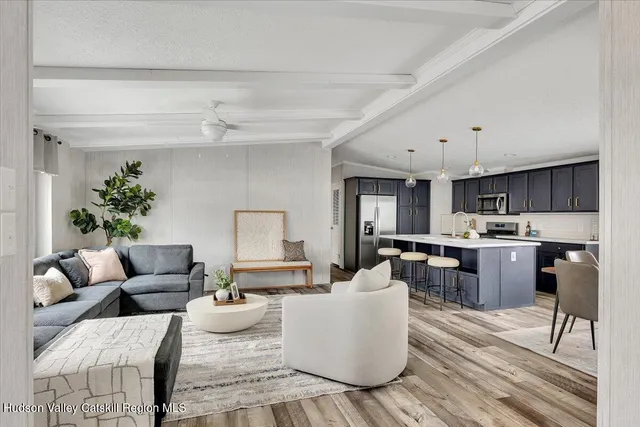 a living room with furniture and view of kitchen