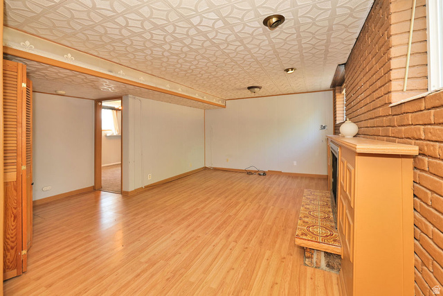 669 Colonial Avenue Layton, UT 84041 - Photo 29 of 51 Brick accent wall with a built-in fireplace, wood-finish flooring, recessed lighting, and a textured ceiling