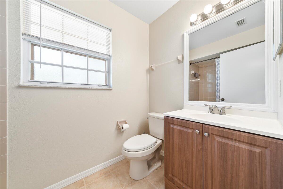 714 Players Court Melbourne, FL 32940 - Photo 15 of 23 a bathroom with a toilet a sink and a mirror