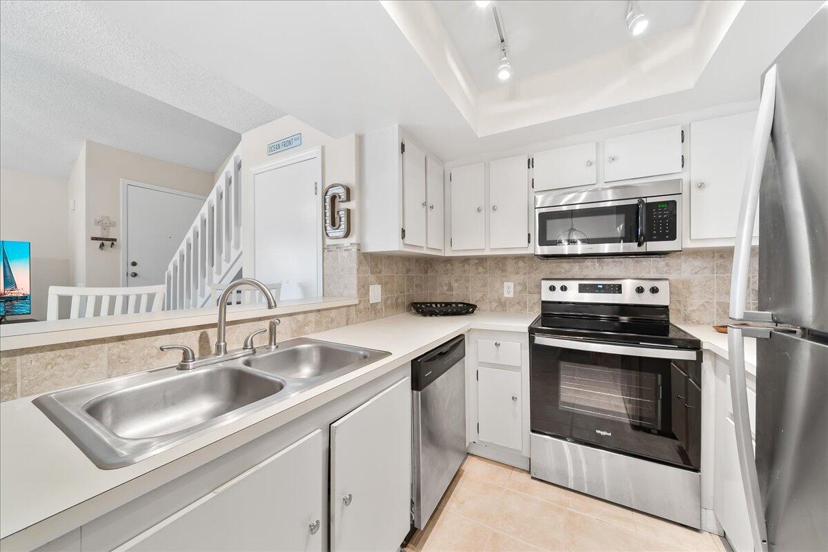 714 Players Court Melbourne, FL 32940 - Photo 7 of 23 a kitchen with stainless steel appliances granite countertop a sink stove a refrigerator and a sink