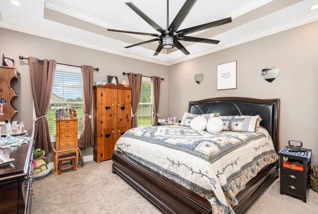 a bedroom with a bed a couch and a chandelier