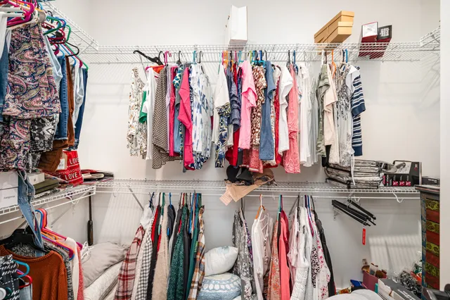 a view of walk in closet with clothes
