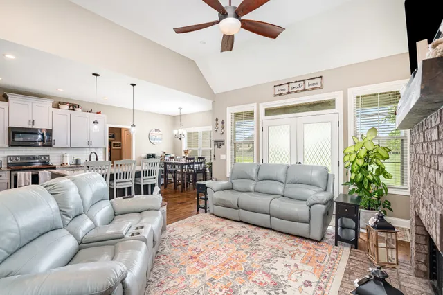 a living room with furniture kitchen view and a potted plant