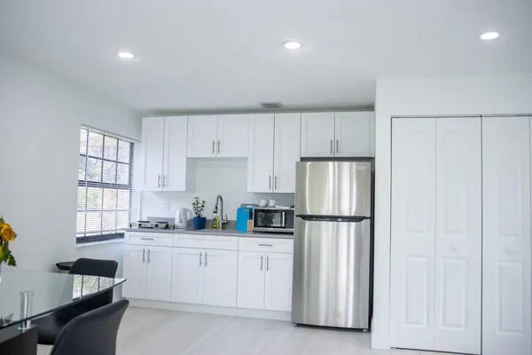 a kitchen with white cabinets and white appliances
