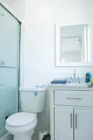a bathroom with a granite countertop toilet sink mirror and vanity