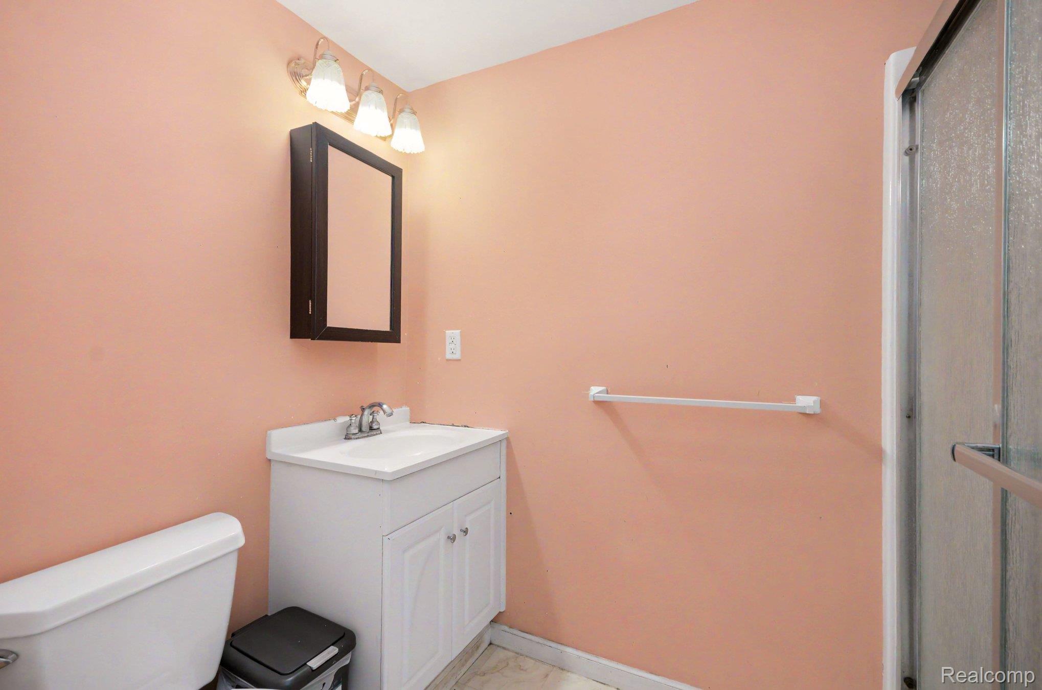 425 Thornridge Court Rochester, MI 48307 - Photo 26 of 35 Bathroom featuring a white vanity with integrated sink, chrome faucet, and a wall-mounted medicine cabinet with mirror