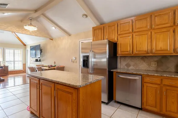 a kitchen with stainless steel appliances granite countertop a sink and a refrigerator