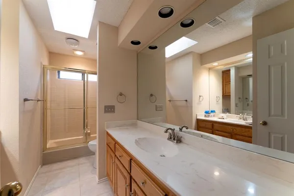 a bathroom with a tub sink shower and mirror