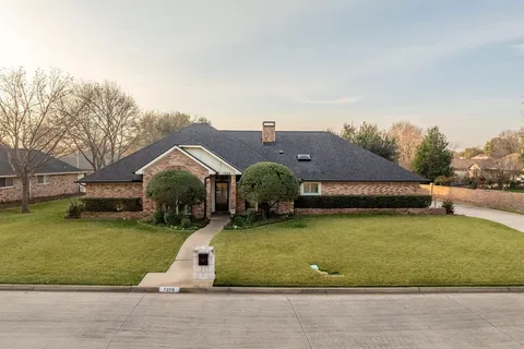 an aerial view of a house with swimming pool and garden