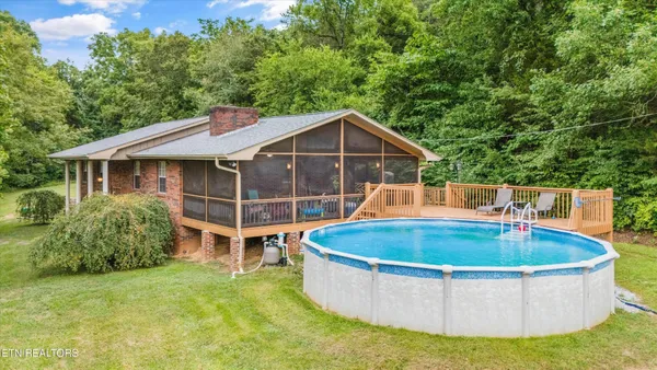 a view of a house with a swimming pool and sitting area