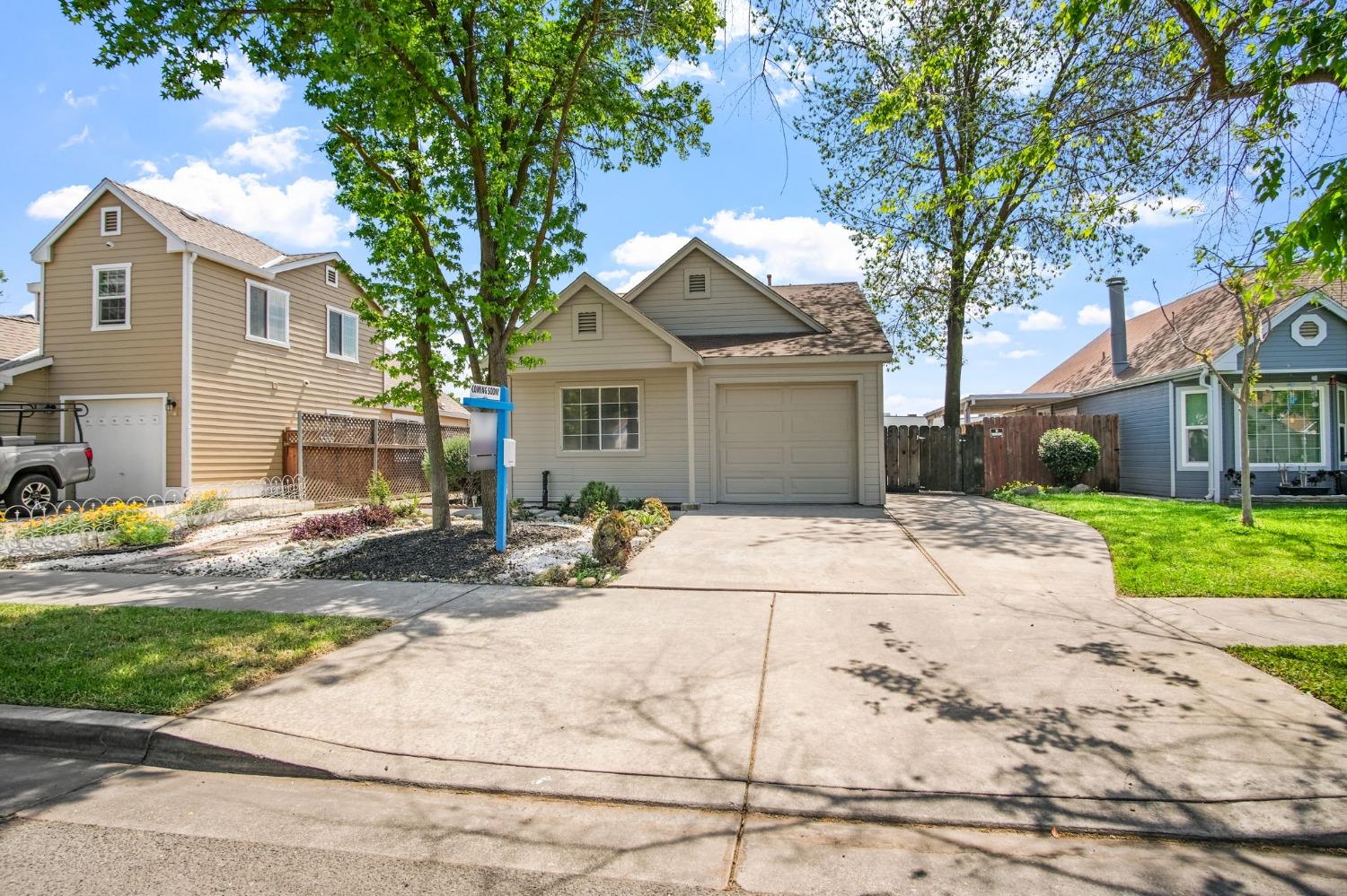 a front view of a house with a yard and potted plants