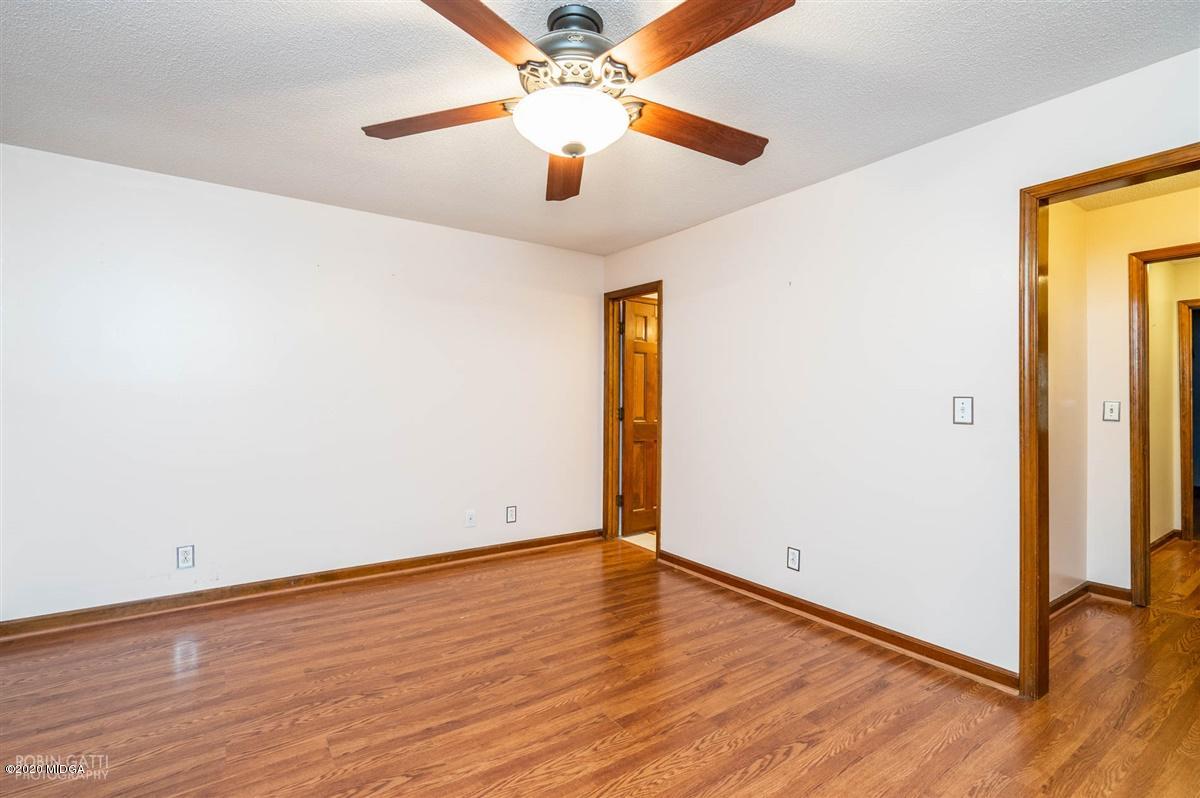 6345 Stapleton Road Macon, GA 31206 - Photo 14 of 21 an empty room with wooden floor chandelier fan and closet area