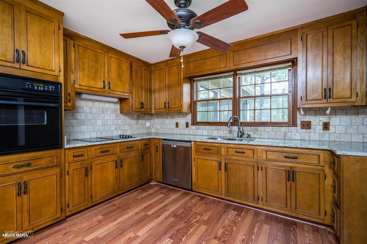 6345 Stapleton Road Macon, GA 31206 - Photo 5 of 21 a kitchen with granite countertop wooden cabinets a sink a window and stainless steel appliances