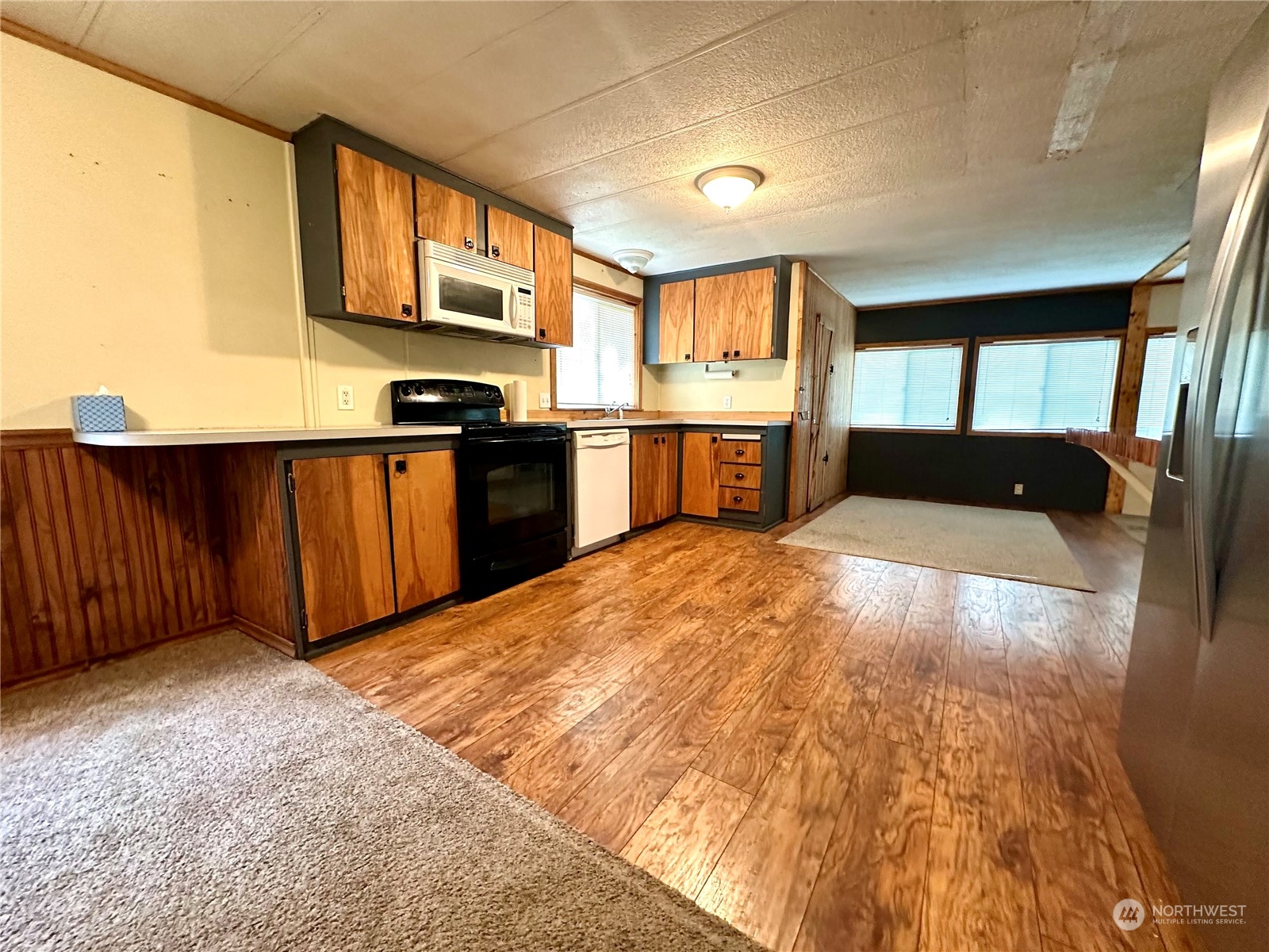 230 Salmon Drive Forks, WA 98331 - Photo 4 of 35 a kitchen with stainless steel appliances granite countertop a refrigerator a stove top oven and a sink with wooden cabinets