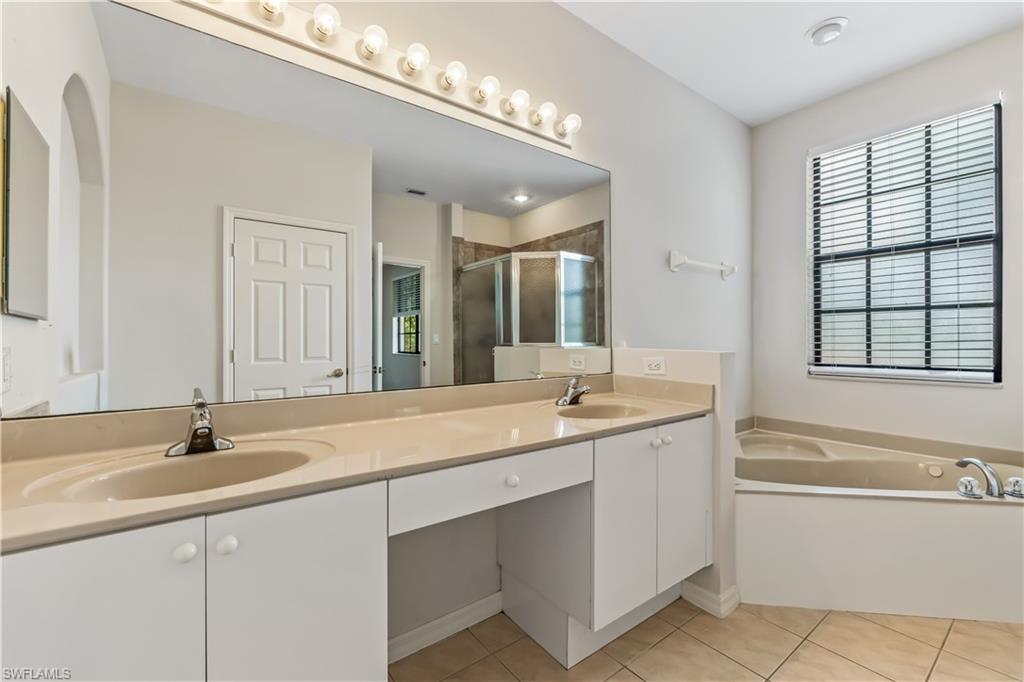 15095 Summit Pl Circle, Unit 377 Naples, FL 34119 - Photo 14 of 38 a bathroom with a sink double vanity a tub and a mirror