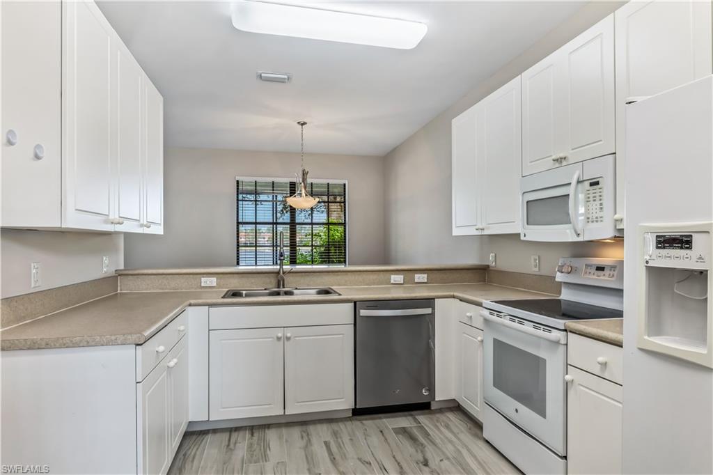 15095 Summit Pl Circle, Unit 377 Naples, FL 34119 - Photo 3 of 38 a kitchen with cabinets appliances a sink and a counter top space