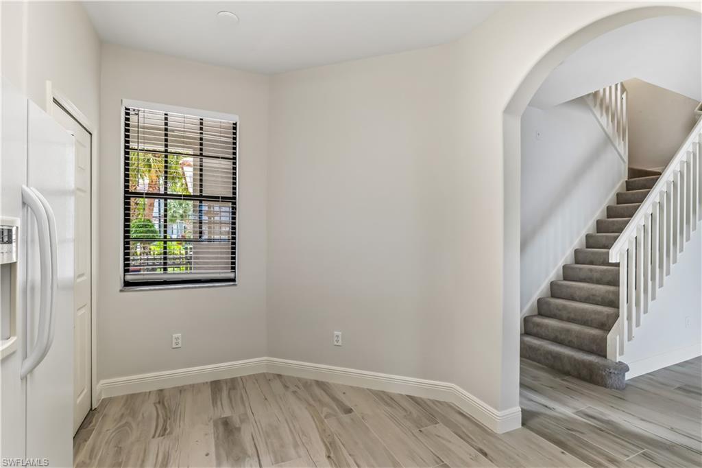 15095 Summit Pl Circle, Unit 377 Naples, FL 34119 - Photo 5 of 38 a view of an empty room with wooden floor and a window
