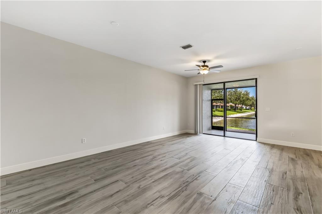 15095 Summit Pl Circle, Unit 377 Naples, FL 34119 - Photo 8 of 38 a view of an empty room with window and wooden floor