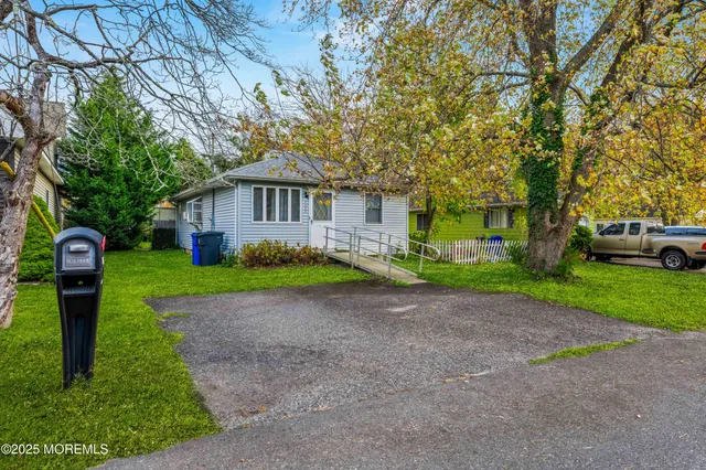 a front view of a house with a garden and trees