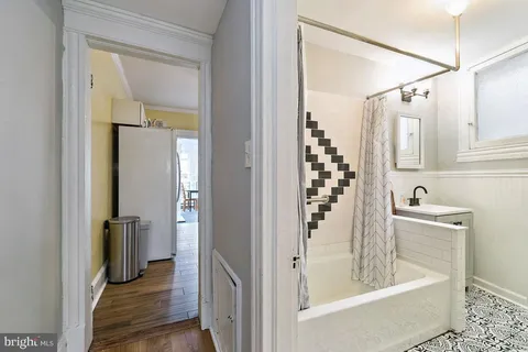 a bathroom with a tub a sink and mirror