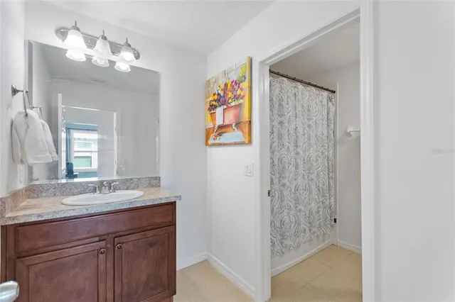 a bathroom with a granite countertop sink a mirror and a shower