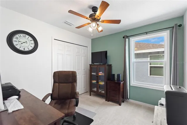 a view of a workspace with furniture and a window