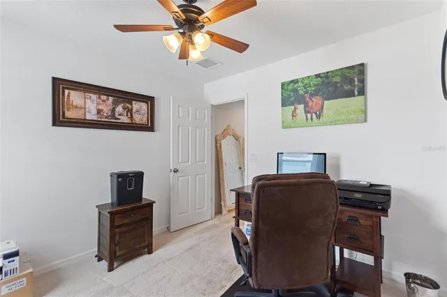 a view of a workspace with furniture and a window