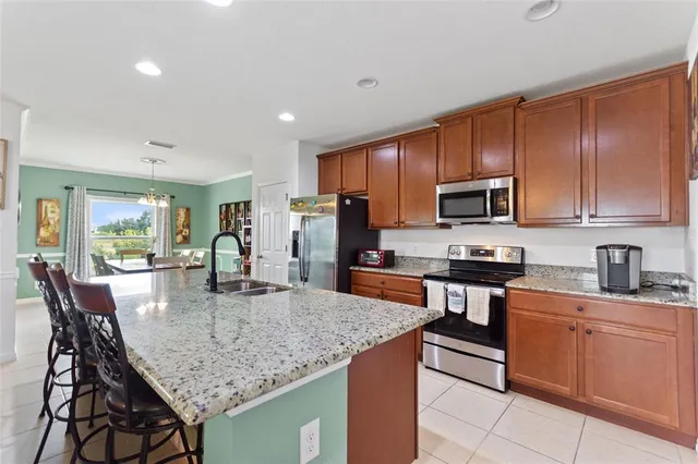 a kitchen with stainless steel appliances granite countertop a kitchen island hardwood floor sink stove dining table and chairs