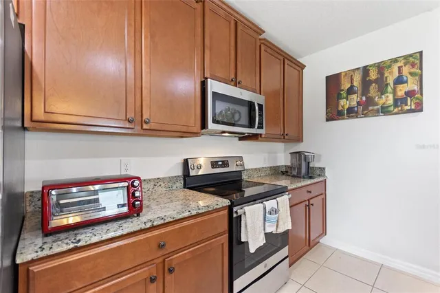 a kitchen with stainless steel appliances granite countertop a stove a sink and a microwave