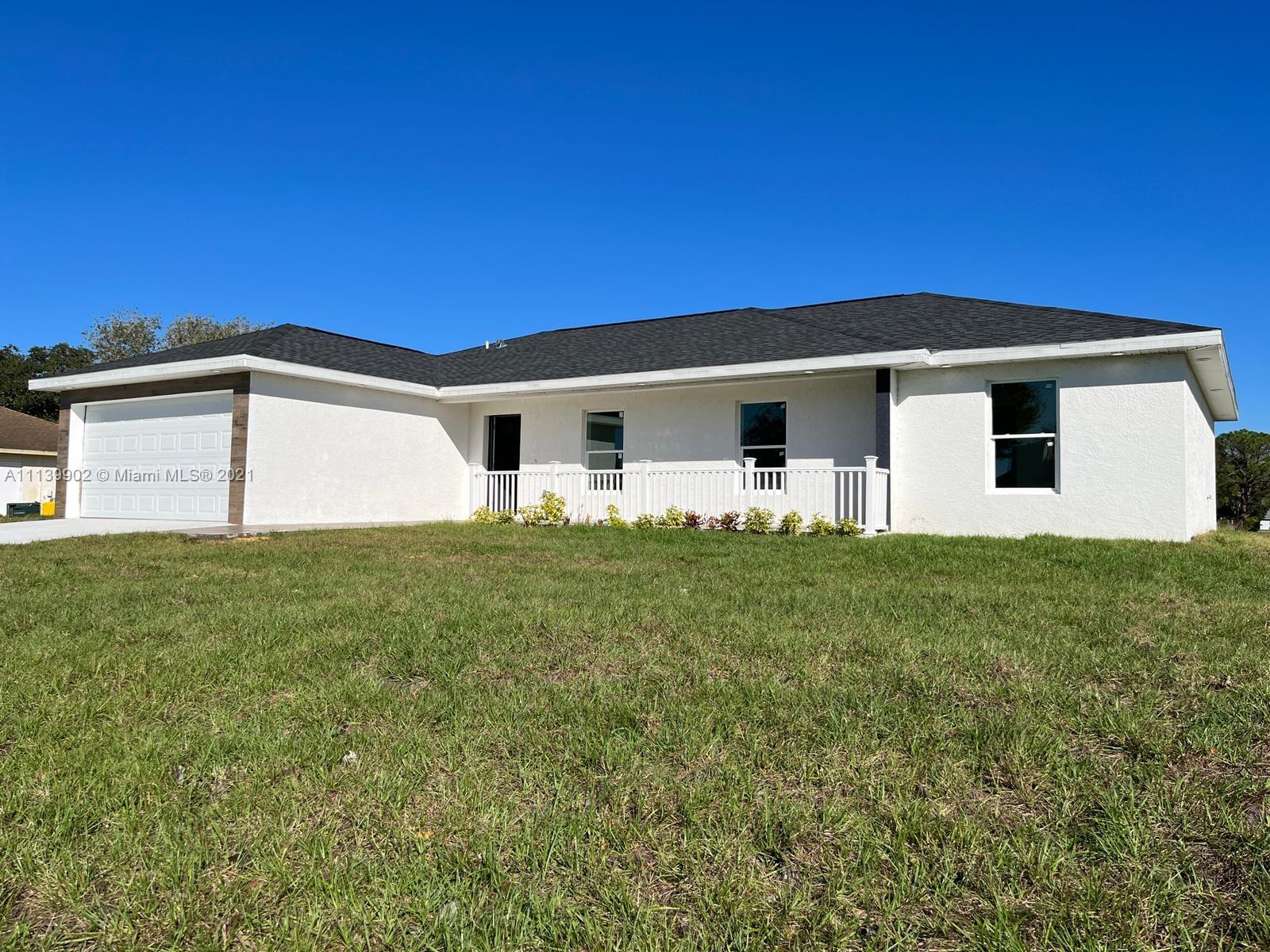 417 Cherry Tree Drive Sebring, FL 33876 - Photo 2 of 39 a front view of a house with a yard