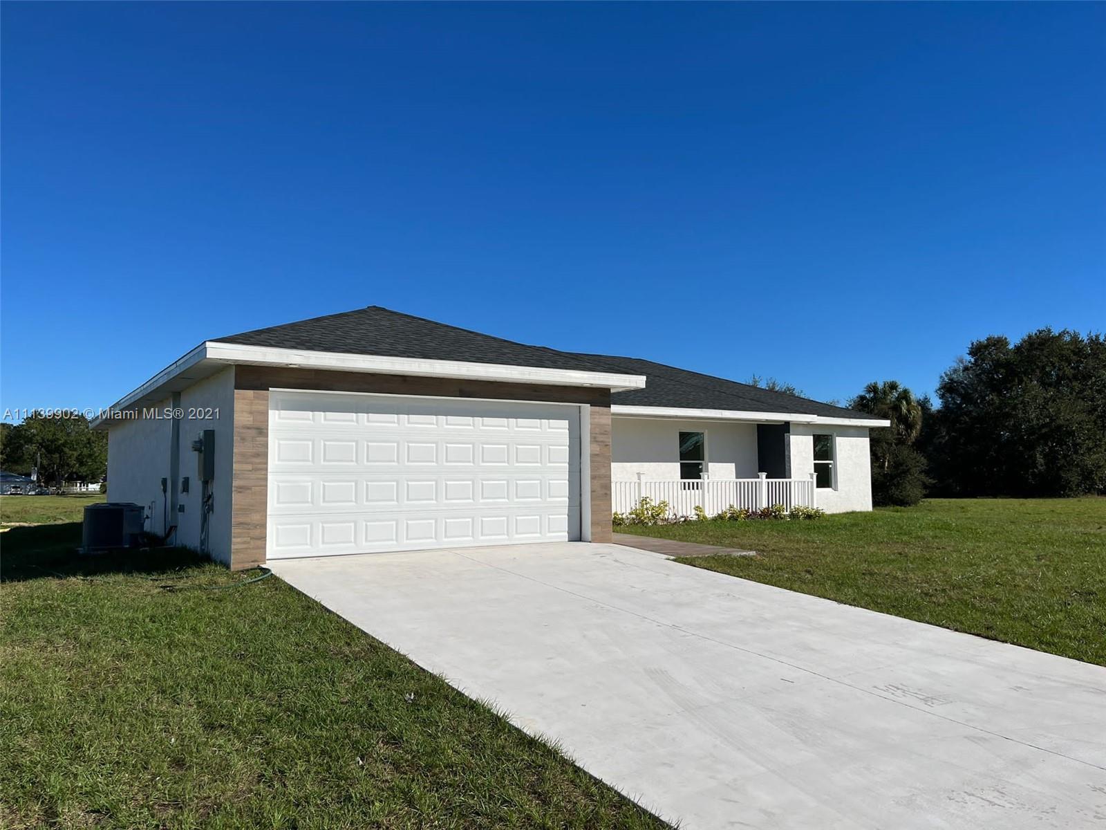 417 Cherry Tree Drive Sebring, FL 33876 - Photo 3 of 39 a front view of a house with a yard and garage