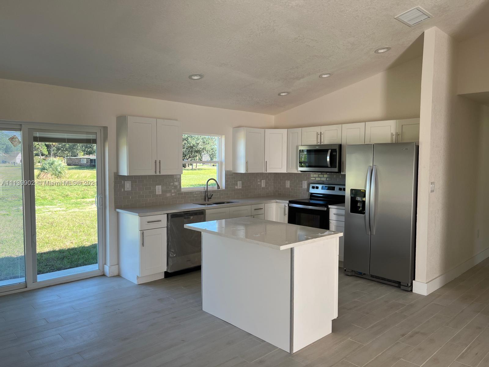 417 Cherry Tree Drive Sebring, FL 33876 - Photo 22 of 39 a kitchen with stainless steel appliances a refrigerator sink and stove