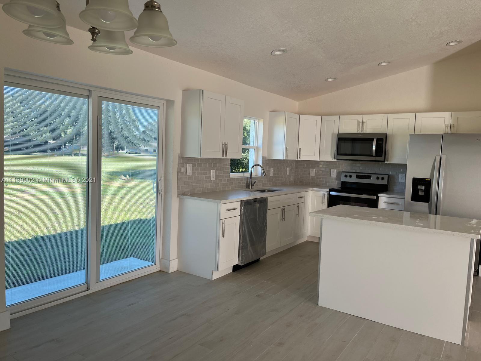 417 Cherry Tree Drive Sebring, FL 33876 - Photo 23 of 39 a kitchen with stainless steel appliances granite countertop a stove a sink and a refrigerator