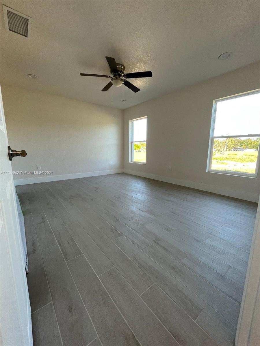 417 Cherry Tree Drive Sebring, FL 33876 - Photo 27 of 39 wooden floor in an empty room with a window
