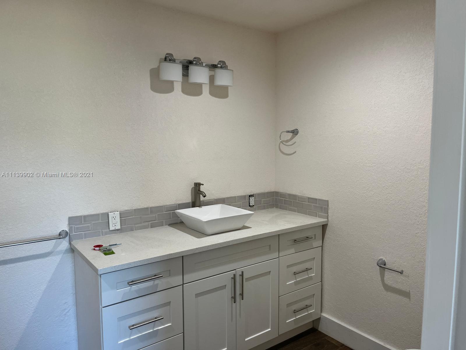 417 Cherry Tree Drive Sebring, FL 33876 - Photo 28 of 39 a bathroom with a sink and a mirror