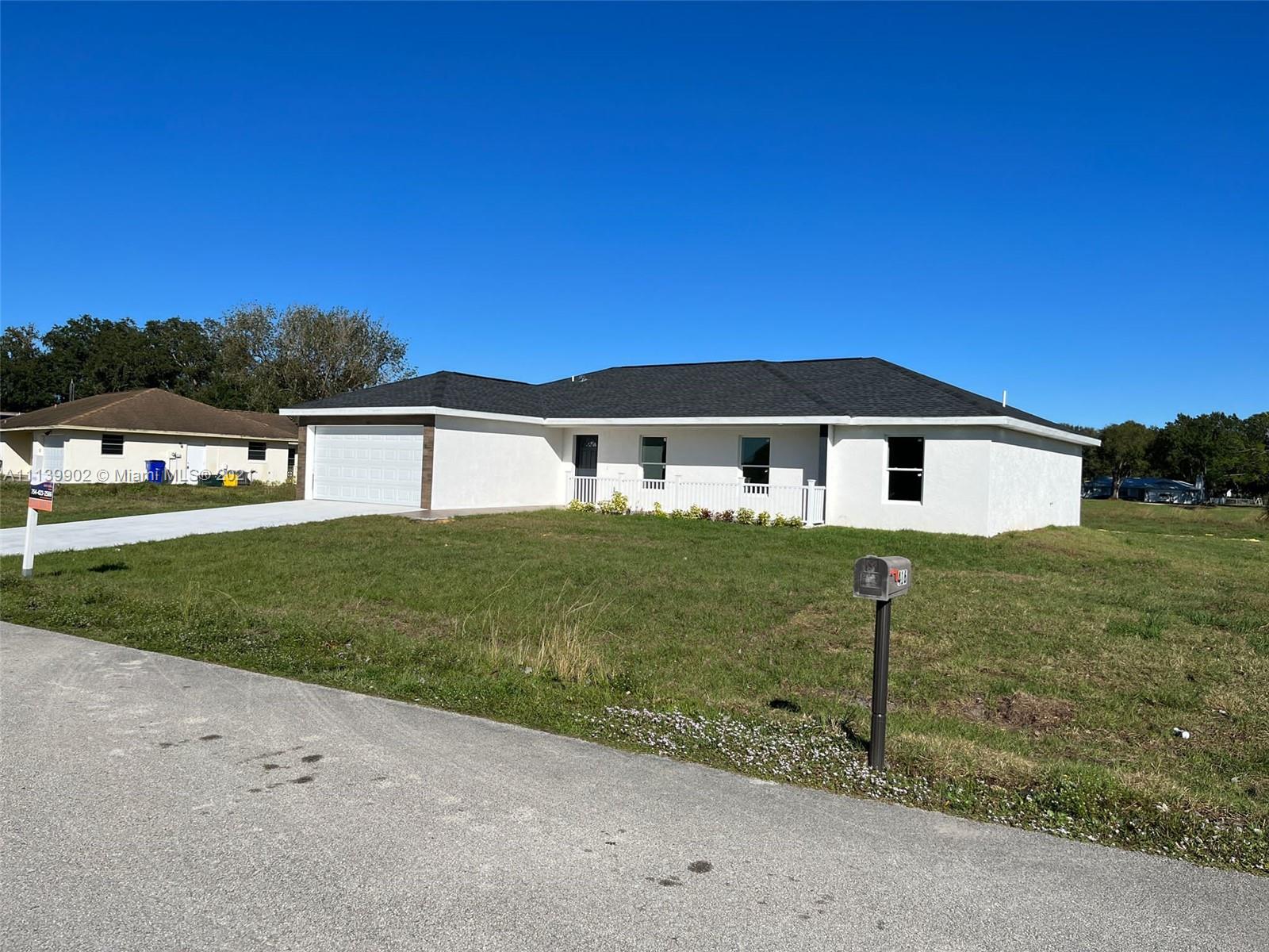 417 Cherry Tree Drive Sebring, FL 33876 - Photo 4 of 39 a front view of a house with a yard