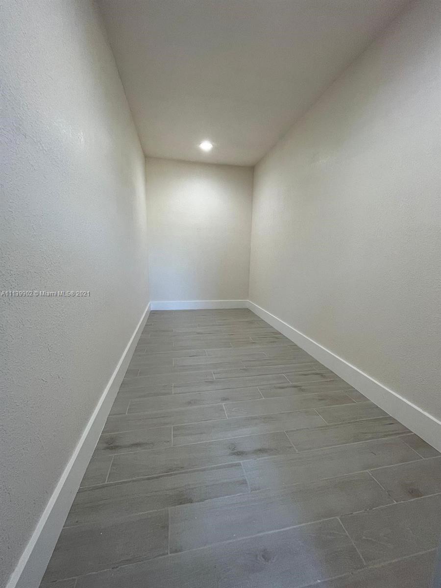 417 Cherry Tree Drive Sebring, FL 33876 - Photo 31 of 39 an empty room with wooden floor and windows