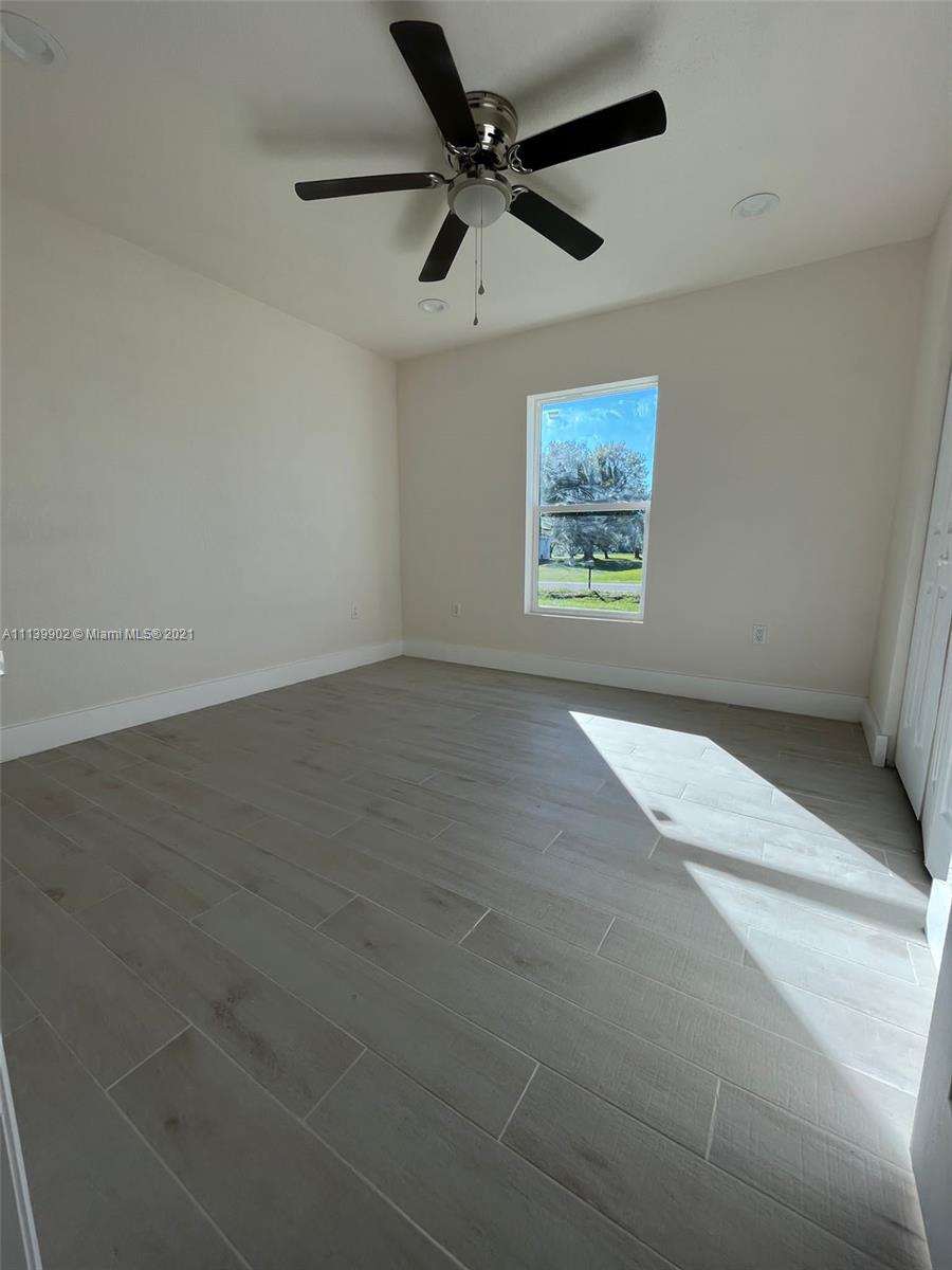 417 Cherry Tree Drive Sebring, FL 33876 - Photo 35 of 39 an empty room with windows and fan view